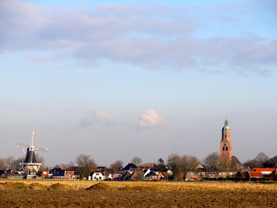 Blick auf Eenrum mit Mühle und Dorfkirche