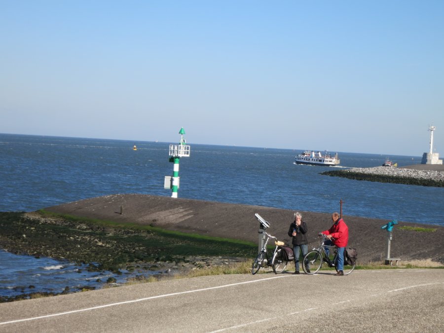 Radfahrer an der Küste bei Den Helder mit Blick auf die Nordsee