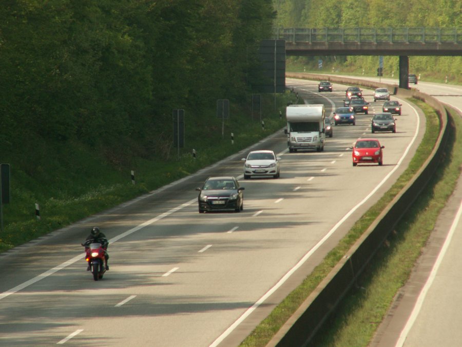 Motorrad und Pkw auf mehrspuriger Autobahn