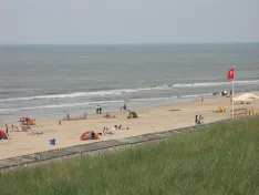 Blick über Dünengras auf Strand und Nordsee bei Egmond aan Zee.